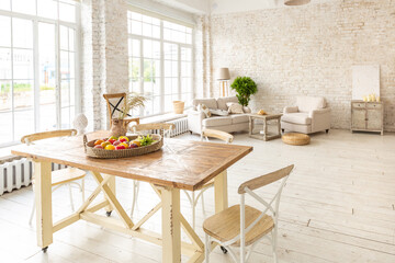 Large spacious room with a trendy loft design of sitting area. huge windows and stylish wicker light furniture inside. an abundance of ethnic decor