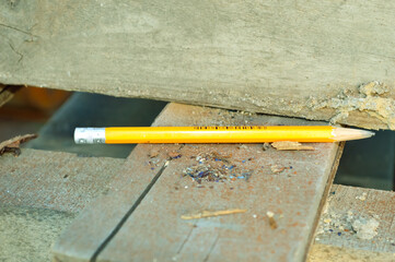 close-up - yellow simple pencil lies on wooden boards at the workplace