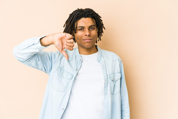 Young african american rasta man showing a dislike gesture, thumbs down. Disagreement concept.