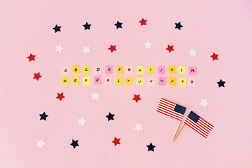 English alphabet completely. Flags usa and many red, white, blue stars around. Multicolored pieces of paper with the abc letters. Studying of foreign language. Concept take exams for green card.