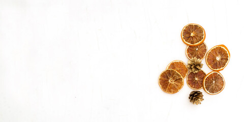 Fototapeta na wymiar Christmas composition. Dried sliced oranges and golden cones on a white background.