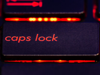 Black keyboard caps lock key with red backlight. 