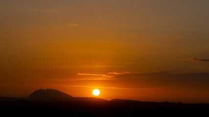 Silhouette of hills against beautiful golden hour sunset and beautiful orange sky