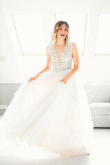 Naklejka premium Luxury bride in white dress posing while preparing for the wedding ceremony