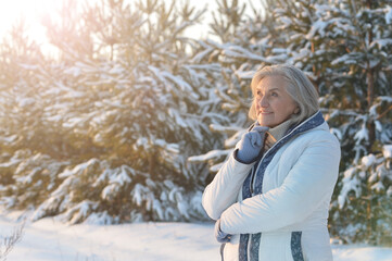 Beautiful senior woman posing in snowy winter park