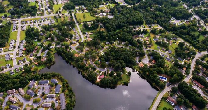 A still pond or lake surrounded by apartments and homes. Sun reflects off surface and clouds can be seen in reflection. A nice establishing shot for anything to do with this part of North Carolina. Su