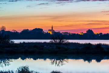 The Constance tower of the fortifications of the medieval city of Aigues-Mortes from the Marette pond at sunrise, in the Gard, in Occitania, France