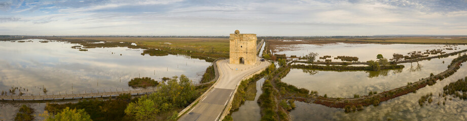 Fototapeta na wymiar Aerial panoramic of the Carbonnière tower in the middle of the Camargue ponds, in Aigues-Mortes in the Gard, in Occitania, France