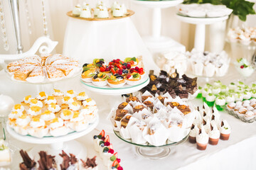 Delicious sweets on wedding candy buffet with desserts, cupcakes