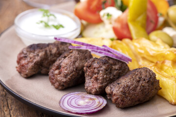 Cevapcici auf dem Teller mit Pommes frites