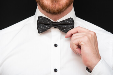 Redhead man with red beard dressed in black bowtie and white shirt 