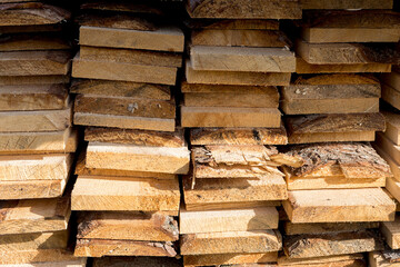 Wooden boards are stored outdoors. Wood texture