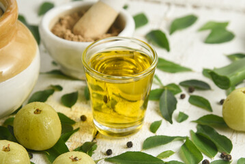 Ayurvedic Oil or Herbal Hair Oil with Herbs tulsi,  curry leaves, oil, amla berry , amla powder , aloe vera ingredients for making medicine Kerala, India. Indian Ayurveda treatment for hair and skin.