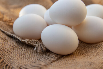 Chicken eggs on a coarse cannabis cloth. Close-up. Selective focus.