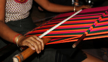 Handloom weaver working in her loin loom at India.