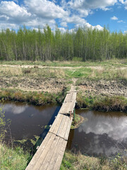 Broken wooden bridge across the river
