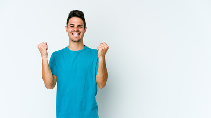Fototapeta premium Young caucasian man isolated on white background cheering carefree and excited. Victory concept.