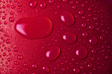 Drops of water on a red glass texture background