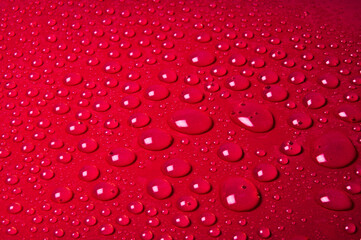 Drops of water on a red glass texture background