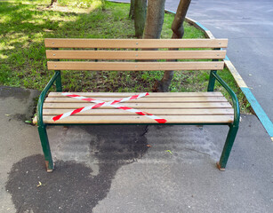 A bench covered with restraining tape. Social distancing. Moscow