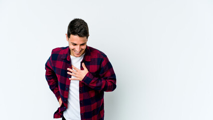 Young caucasian man isolated on white background laughing keeping hands on heart, concept of happiness.