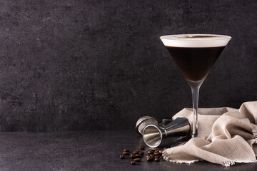 Martini espresso cocktail in glass on black background.Copy space	