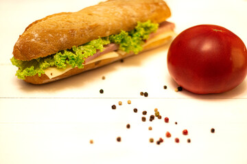 sandwich with salad and vegetables on white table