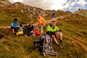 A young family with children travel through the mountains of the Carpathians, rest and gain strength to go further, admiring the scenery.