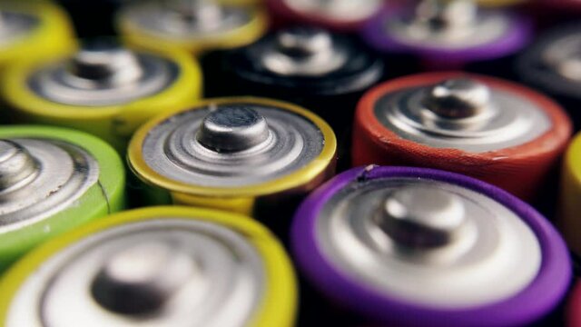 lots of alkaline used AAA batteries background. the video rotation