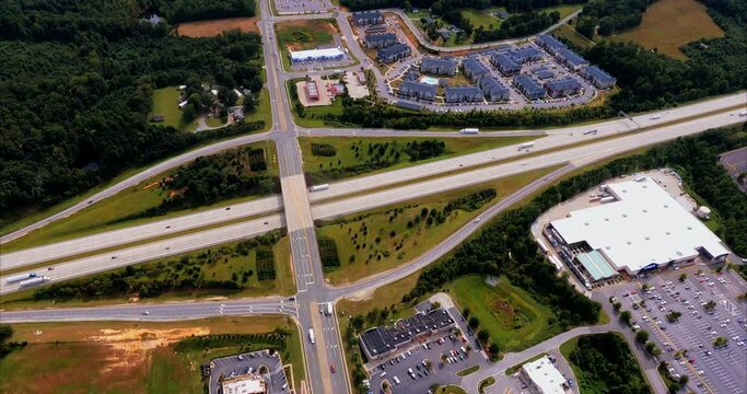 I fly over an exit 124 on interstate I-85 in Greensboro, NC and we see individual food restaurants on one side of the highway. Large parking lots that are mostly empty during the coronavirus pandemic.