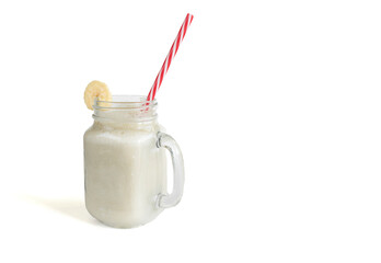 Fresh banana smoothie in a glass jar with a straw, on a white isolated background. Healthy food. Vegetarian food.