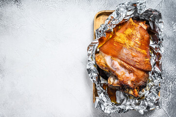 Roast pork knuckle with pepper and spices. Gray background. Top view. Copy space