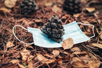 Coronavirus in autumn. Medical mask in autumn. Using masks in the fall. bump and mask lying on the ground which is covered with autumn colors and leaves 