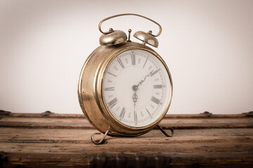 Vintage Metal Alarm Clock on Old Wooden Trunk