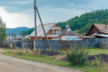landscape russian village in mountain  rocks summer. Mountain nature, clean air.  Picturesque authentic village  surrounded by mountains. Small houses and gardens in a valley  background from nature