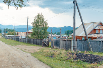 landscape russian village in mountain  rocks summer. Mountain nature, clean air.  Picturesque authentic village  surrounded by mountains. Small houses and gardens in a valley  background from nature