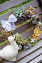 ベンチの上のリースと白いアヒルのオブジェ