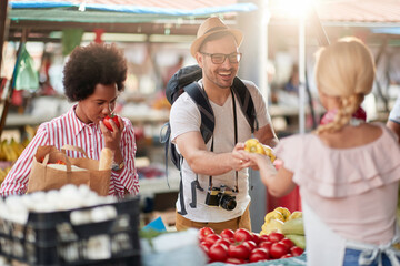 Seller woman offers fresh and organic vegetables at the green market or farmers market stall.  Young buyers choose and buy products for healthy food in grocery. All for diet healthy eating, lifestyle.
