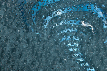 Whirl. Water droplets rotate in different directions against a turquoise background. Abstract fantasy