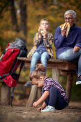 Fototapeta premium Grandmother and grandchildren on the break of hiking in the forest