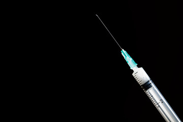 Closed syringe isolated on black background