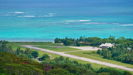 Aerial view of airfield located near the coast in the north of Praslin island, Seychelles with a small plane parking in front of the terminal building.