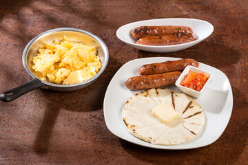 Tasty Colombian breakfast; White corn arepa with chorizo and scrambled eggs.