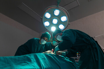 The surgeon is working in a hospital operating room.