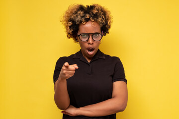 It is your fault. Disappointed angry young african woman frowning pointing index finger at camera,