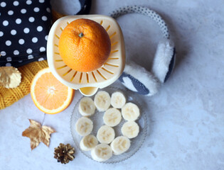 hand juicer for oranges, banana slices and autumn accessories. Lifestyle composition. Top view.