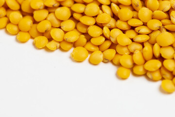 Yellow  lentils scattered on a white background