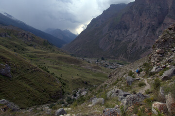 Backpackers trekking in mountains.
Tourists hike through the valley. Valley near Bulungu village. Caucasus, Russia.