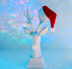 white deer in santa hat in multicolored disco lights, a concept for celebrating Christmas and New year