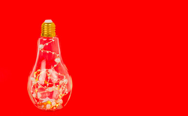 lamp with garland on red background, minimal creative concept of Christmas and New Year